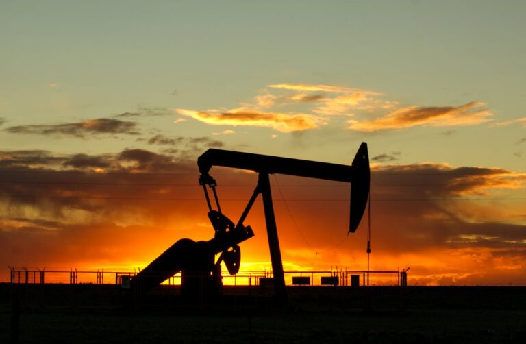 Oil well pump jack at sunset representing commodity and oil investing in South Africa