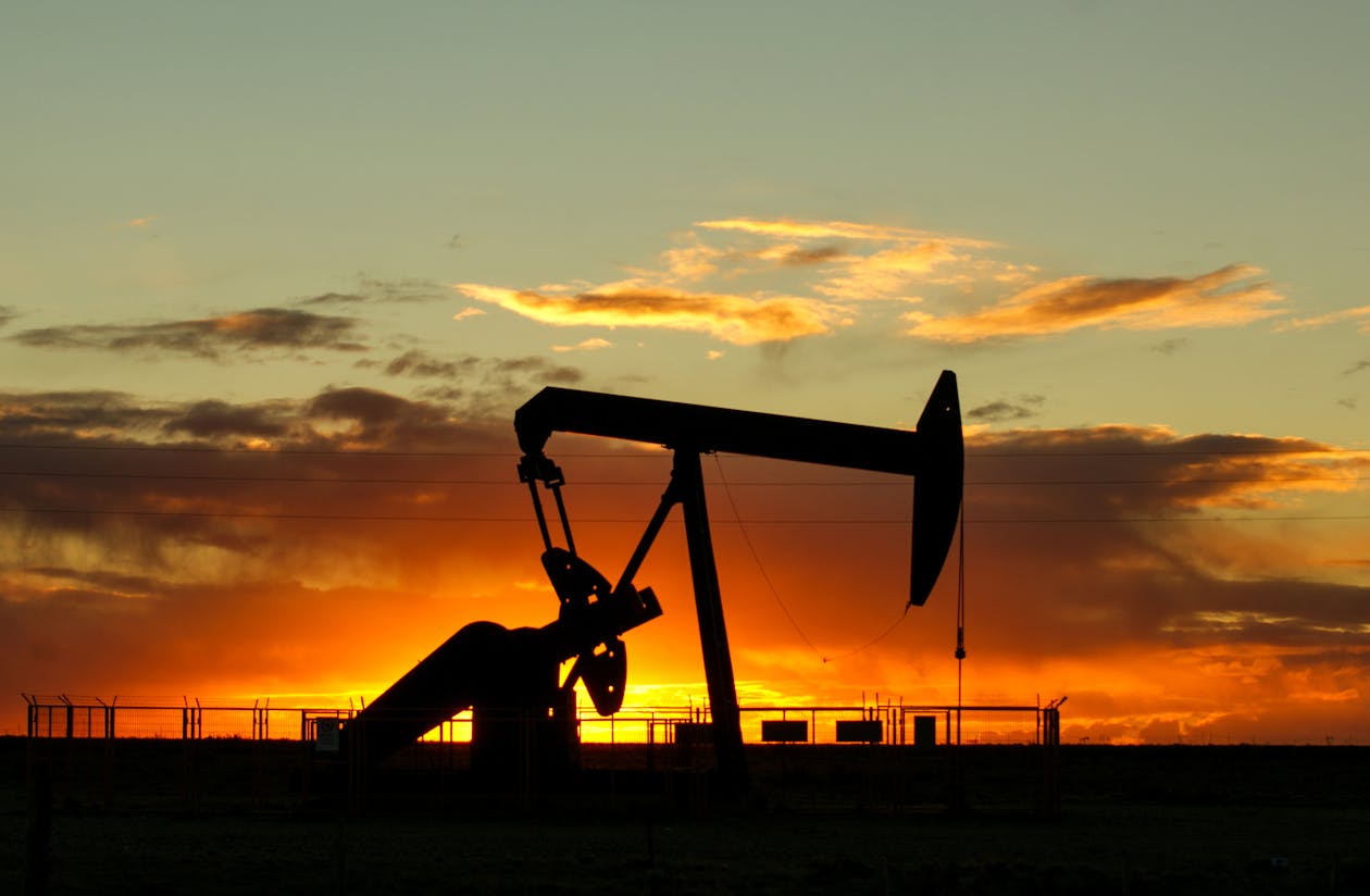 Oil well pump jack at sunset representing commodity and oil investing in South Africa