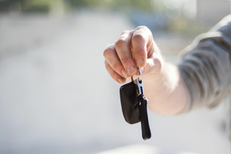 Hand handing over car keys, representing car finance and vehicle purchase