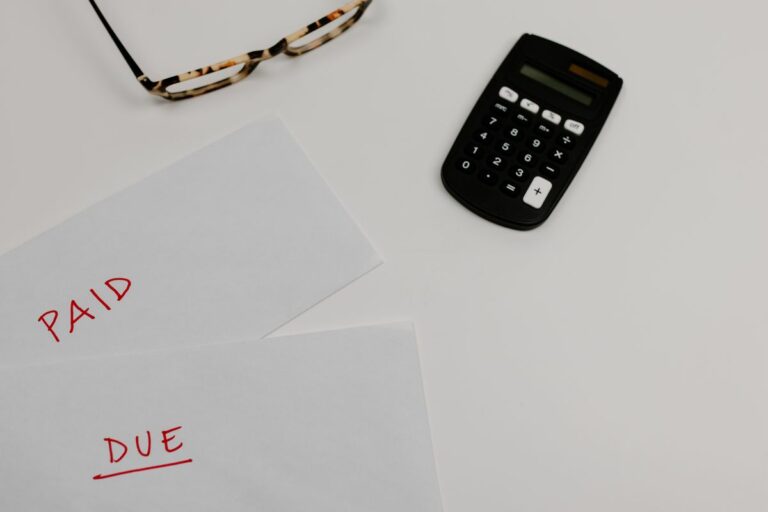 Black calculator beside white papers on a desk