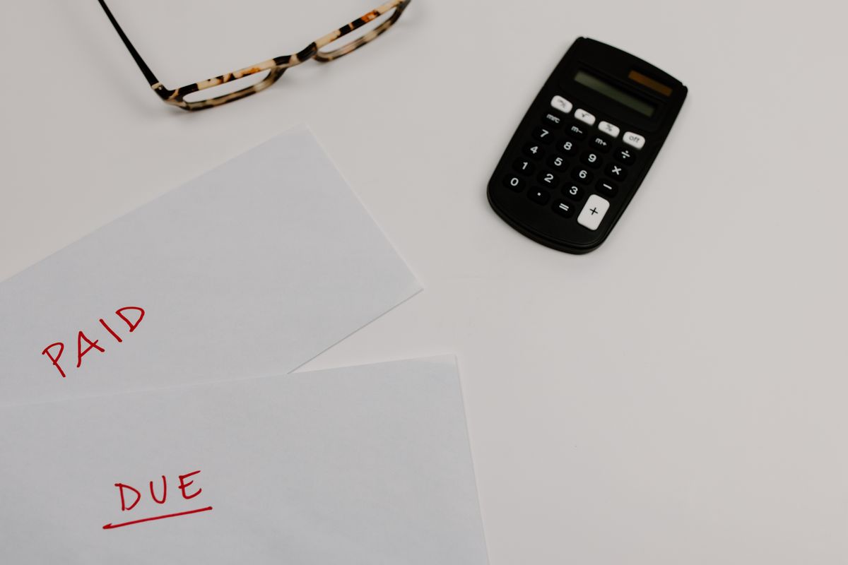 Black calculator beside white papers on a desk